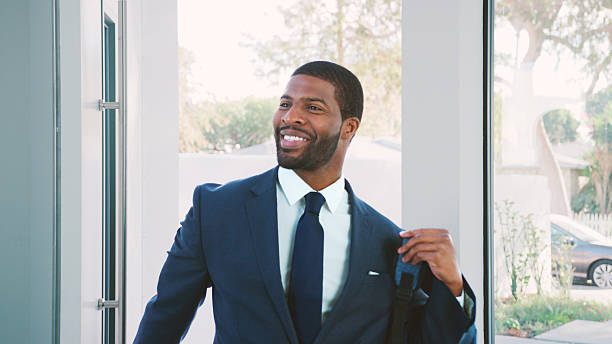 Businessman Wearing Suit Opening Door Returning Home From Work