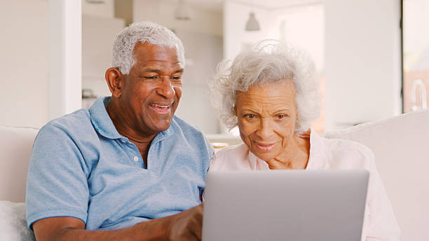 istock Senior Couple Sitting On Sofa At Home Together Using Laptop 2246198189