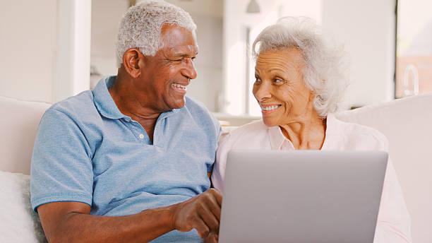 istock Senior Couple Sitting On Sofa At Home Together Using Laptop 2246198202