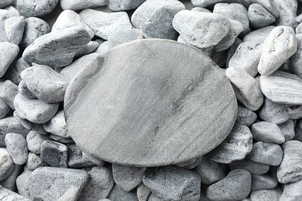 Presentation for product. Stone podium on grey pebbles, top view