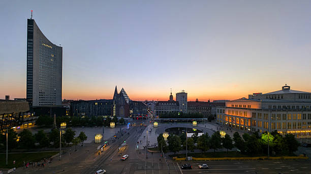 Leipzig, Germany, 09. May 2025 elevated viewpoint overlooking the egyptian museum the Nikolai Church the paulinium City-Hochhaus and the opera house on Augustusplatz at golden hour under a clear, warm  blue orange sky