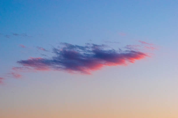 Soft pink cloud floating in a colorful evening sky over the Adriatic Sea, captured at sunset near Trieste.