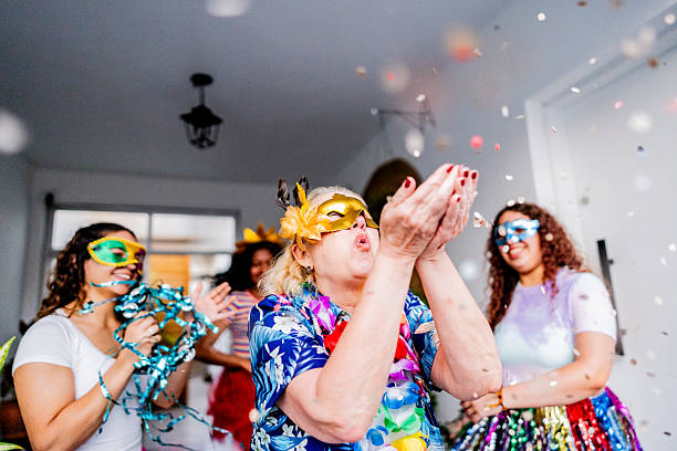 istock Senior woman blowing confetti during carnival celebration 2246201410