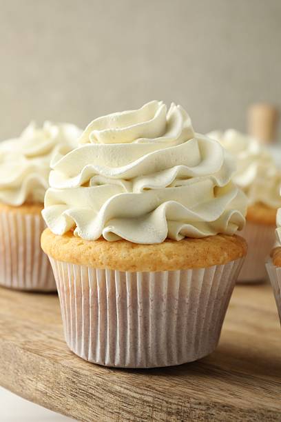 istock Tasty vanilla cupcakes with cream on table, closeup 2246201752