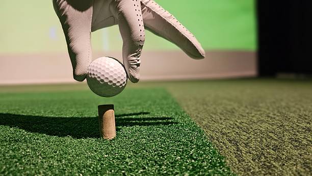 istock Golf ball getting ready to be struck from a tee at an indoor simulation facility concept 2246201904