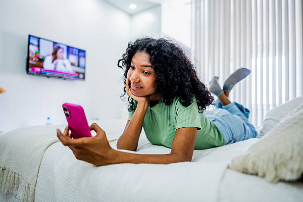 istock Young woman enjoying mobile phone at home 2246203246