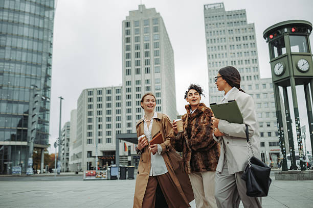 istock Three businesswomen having coffee break together while walking in city 2246203625