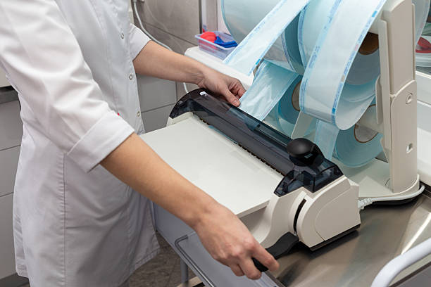 istock A dental assistant uses a heat sealing machine to package instruments 2246204644