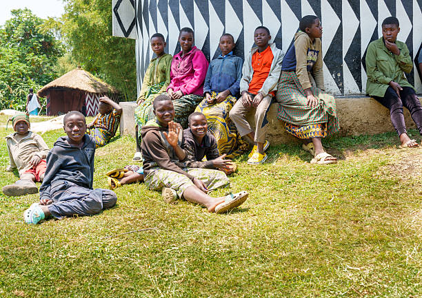 Kayonza, Rwanda - November 2, 2007: A group of three children in different ages are playing on a local dirt road and are watching curious into the direction of the camera. Some of the children are dressed very poorly. Location: Kayonza village in Eastern Rwanda, close to the border to Tanzania.