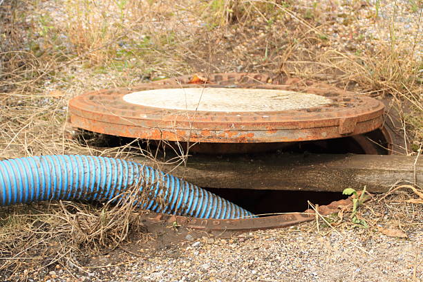 istock Hose is led into a sewage pipe and secured with a square timber 2246206615