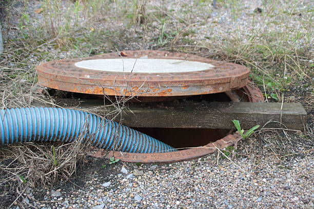 istock Hose is led into a sewage pipe and secured with a square timber 2246206621