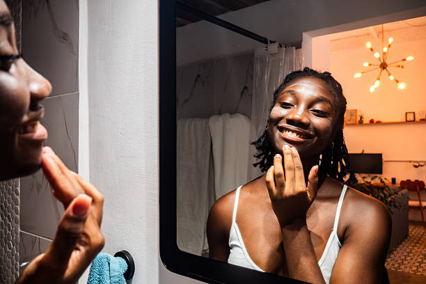 istock Young woman applying cream to her face 2246207692