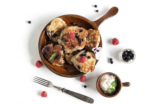 Homemade pancakes with fresh berries and cream served on white. breakfast still life.