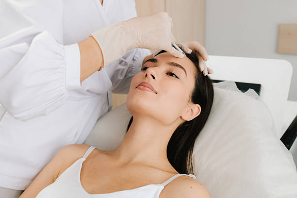 istock Non-surgical forehead rejuvenation with botulinum toxin. Forehead Injection close-up. Forehead botulinum toxin injection smooths fine lines and relaxes muscles. 2246209770