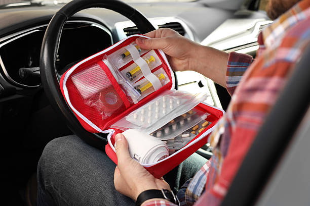 istock Man holding first aid kit with medicaments inside car, closeup 2246210558