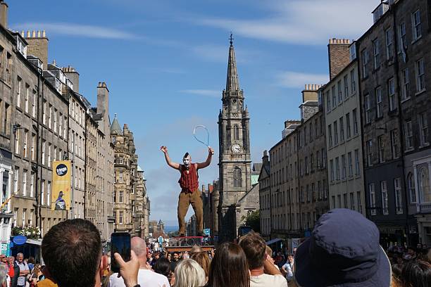 Edinburgh, Scotland - 18 August 2025: A juggler on a balancing platform has attracted a large audience.