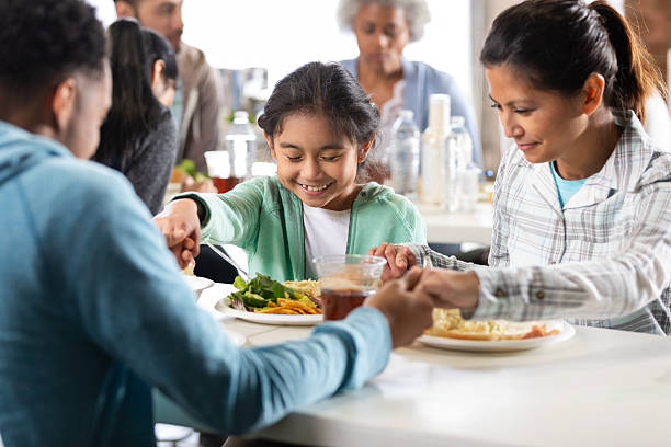 istock Multi-generational family holds hands in prayer before sharing a meal together. 2246212251