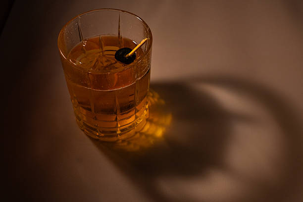 istock Moody Whiskey Glass with Cherry Garnish and Dramatic Shadows 2246212661