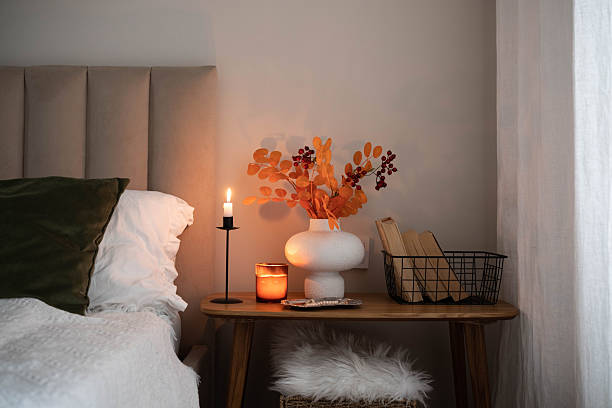istock Cozy fall decor in a light and bright bedroom, bed, white bed sheets, autumn branches in white vase, candles and books on wooden bench. 2246212683