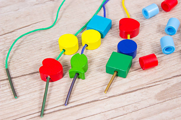 Thread, creative sticks and colorful beads used to making bracelets, learn counting and arranging various shapes. Development of kids motor skills, creativity and coordination