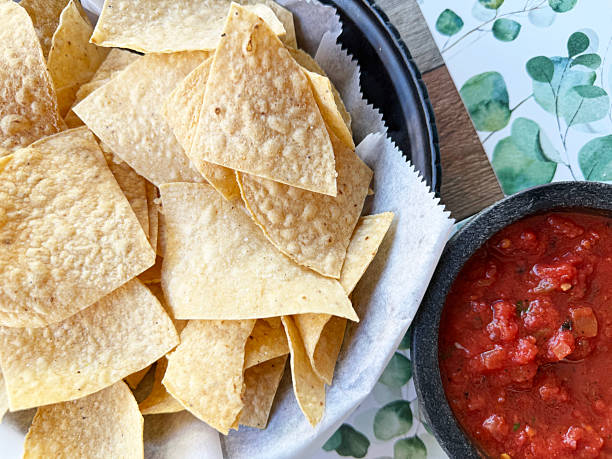 istock Crispy tortilla chips served with fresh salsa on a decorative table with green foliage 2246215578