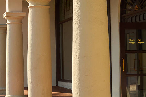istock Close-up of sunlit stucco columns by arched entry 2246218905