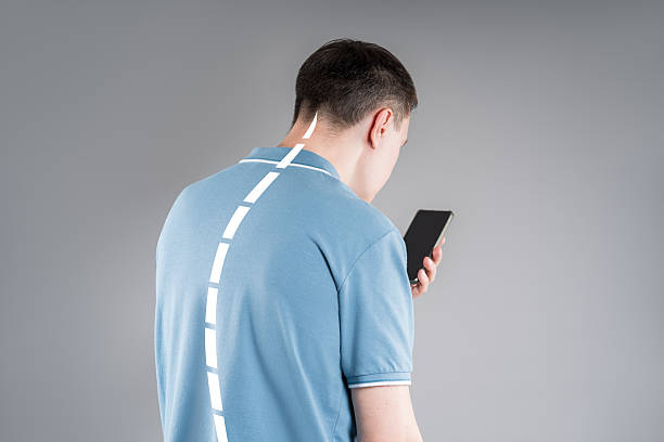 Man with neck pain from using smartphone, text neck and bad posture concept stock photo