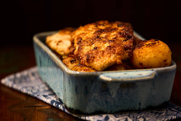 Fried chicken breast with potatoes. Rustic wooden background. Soft focus.