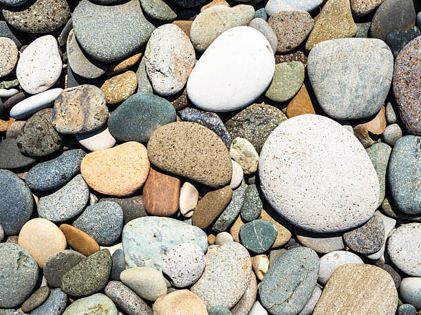 Colorful rocks and pebbles scattered along the beach overlooking Ballycotton Bay in County Cork, Ireland