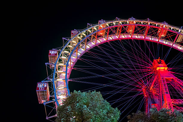 istock Illuminated Ferris Wheel at Night with Vibrant Red and Yellow Lights 2246226478