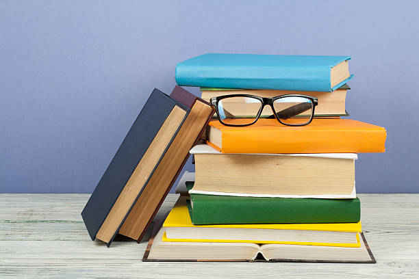 istock Open book, hardback colorful books on wooden table. Glasses. Back to school. Copy space for text. Education business concept. 2246226503