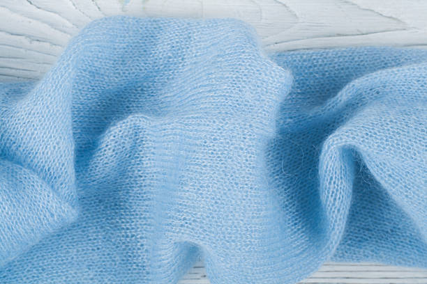 istock Sweater or scarf fabric texture large knitting. Knitted jersey background with a relief pattern. Wool hand- machine, handmade, blue. 2246226824