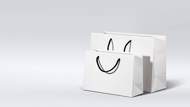 istock Two white paper shopping bags with black handles on light grey gradient background. Concept of seasonal shopping, online purchase, retail sale and minimalist gift packaging. Copy space, banner, mockup 2246229354