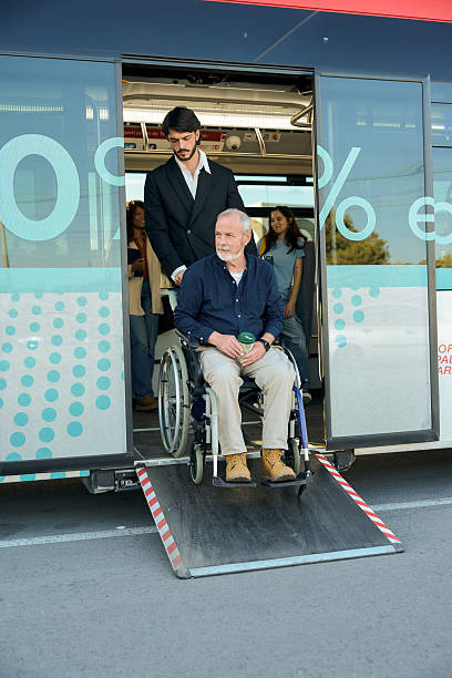 istock Young man helping senior man on wheelchair exit bus 2246230608