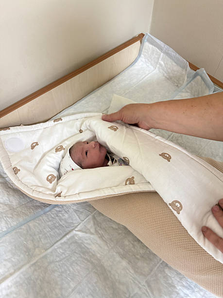 istock Newborn baby being gently covered with soft blanket by parent 2246230706