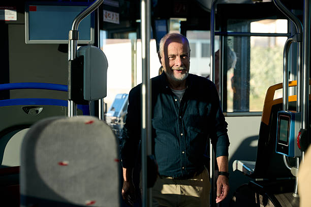 istock Senior man smiling standing inside public bus 2246230766