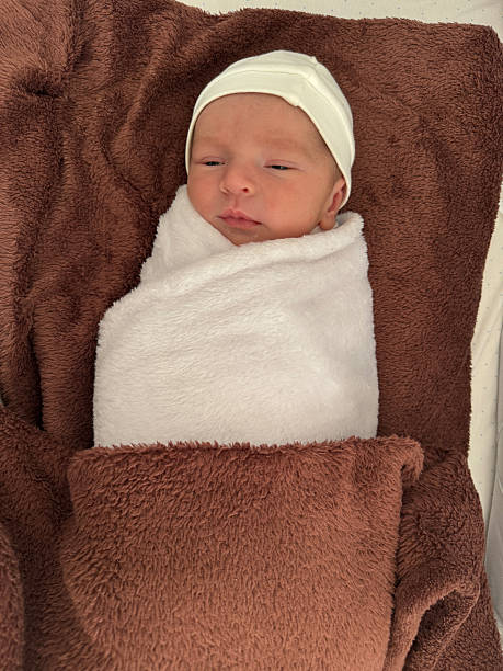 istock Newborn baby wrapped in white blanket resting peacefully 2246230908