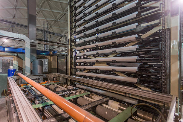 A toilet paper winding machine in a factory workshop. Specialized equipment for various types of paper products.