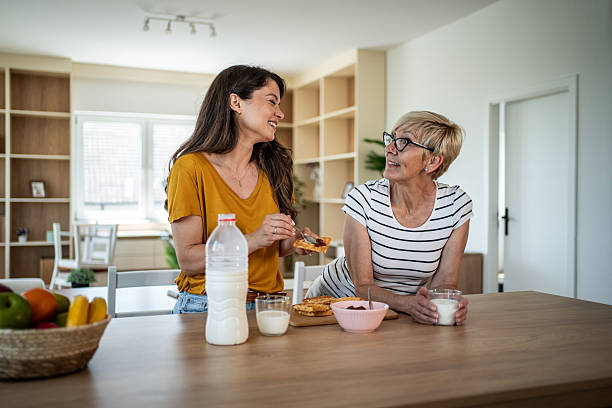 istock Mother daughter enjoying breakfast spreading jam on toast 2246232358
