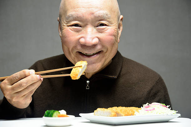 istock Seniors smiling as they eat Japanese pork dishes 2246233529