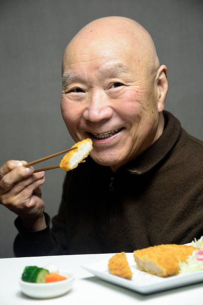 istock Seniors smiling as they eat Japanese pork dishes 2246233530