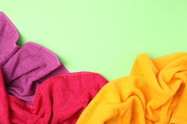 istock Bright terry towels on green background, flat lay. Space for text 2246233656