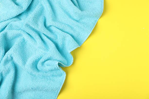 istock Light blue terry towel on yellow background, top view. Space for text 2246233684