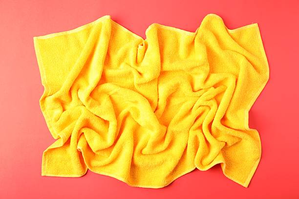 istock Yellow terry towel on red background, top view 2246233697