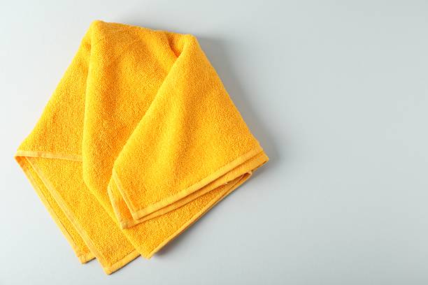istock Yellow terry towel on light grey background, top view. Space for text 2246233724