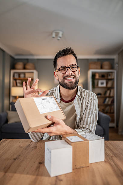 istock Satisfied man holding delivered package after online shopping 2246234228