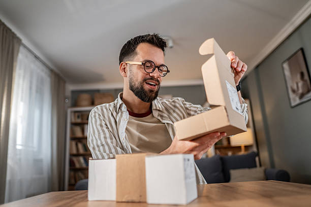 istock Man unboxing parcel at home after online shopping 2246234319