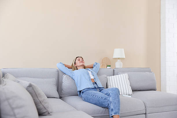 istock Beautiful woman relaxing on sofa at home 2246234391