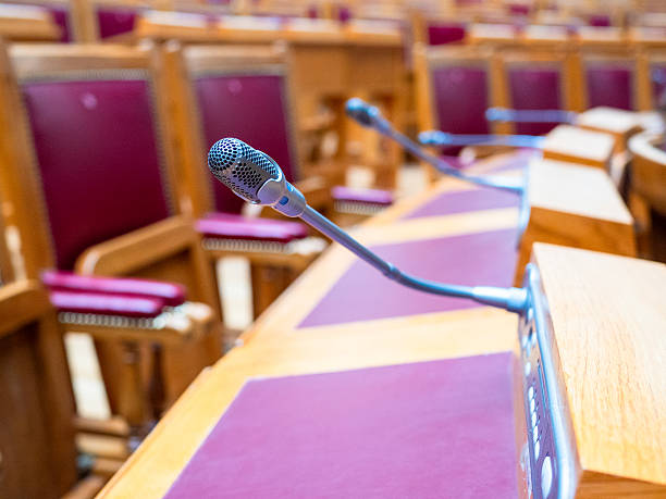 istock microphone closeup at desks in conference hall 2246234617