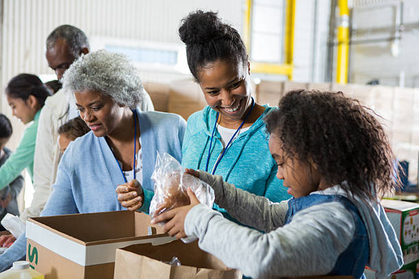 istock Diverse group of people working together, volunteering to pack donations for those in need. 2246234891